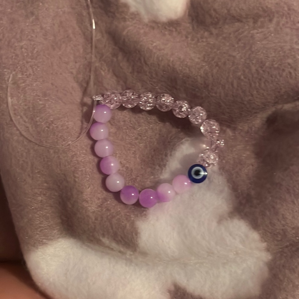 homemade purple bead evil eye bracelet with stretchy string.